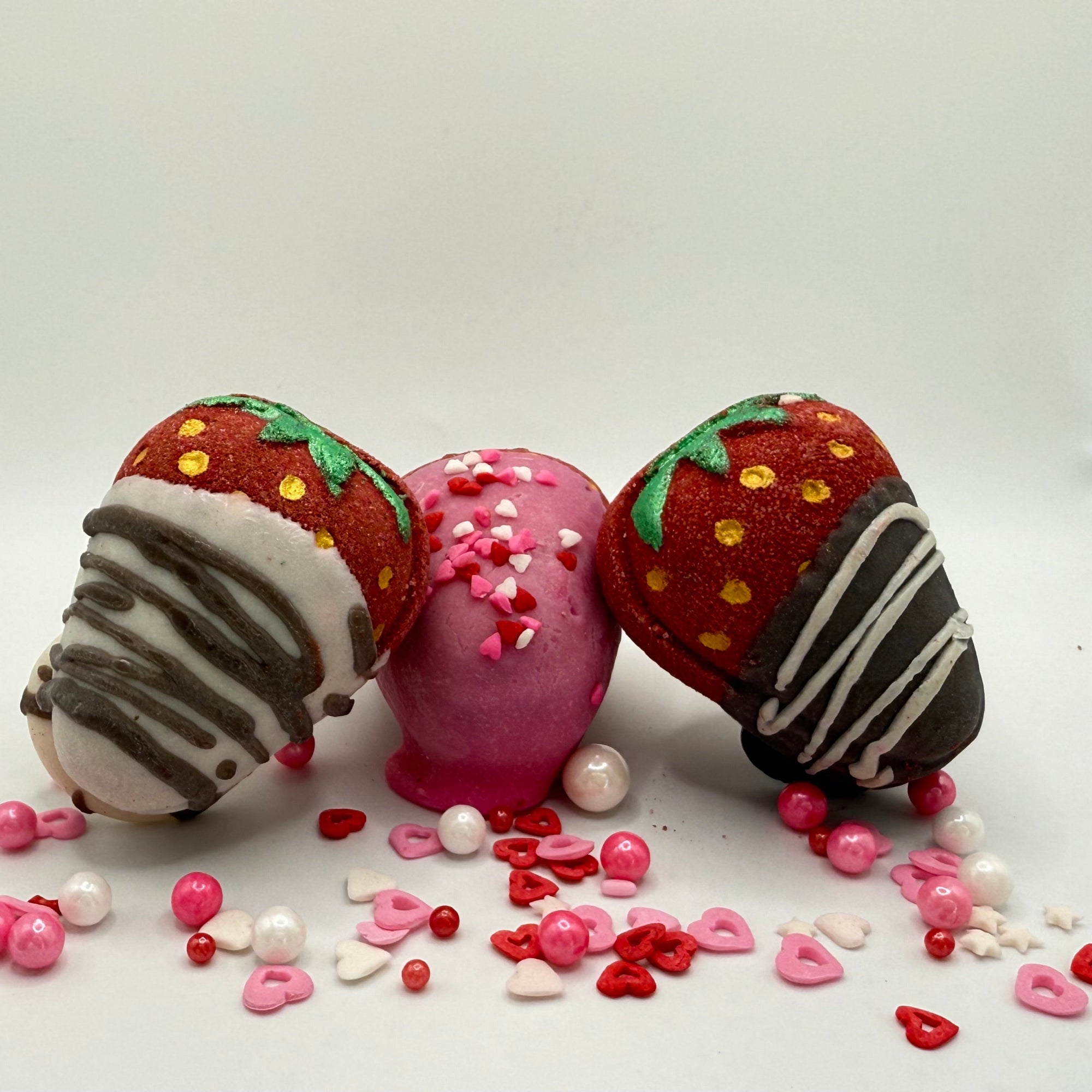 Three chocolate covered strawberry bath bombs made by Rusted Acre Soap Company.