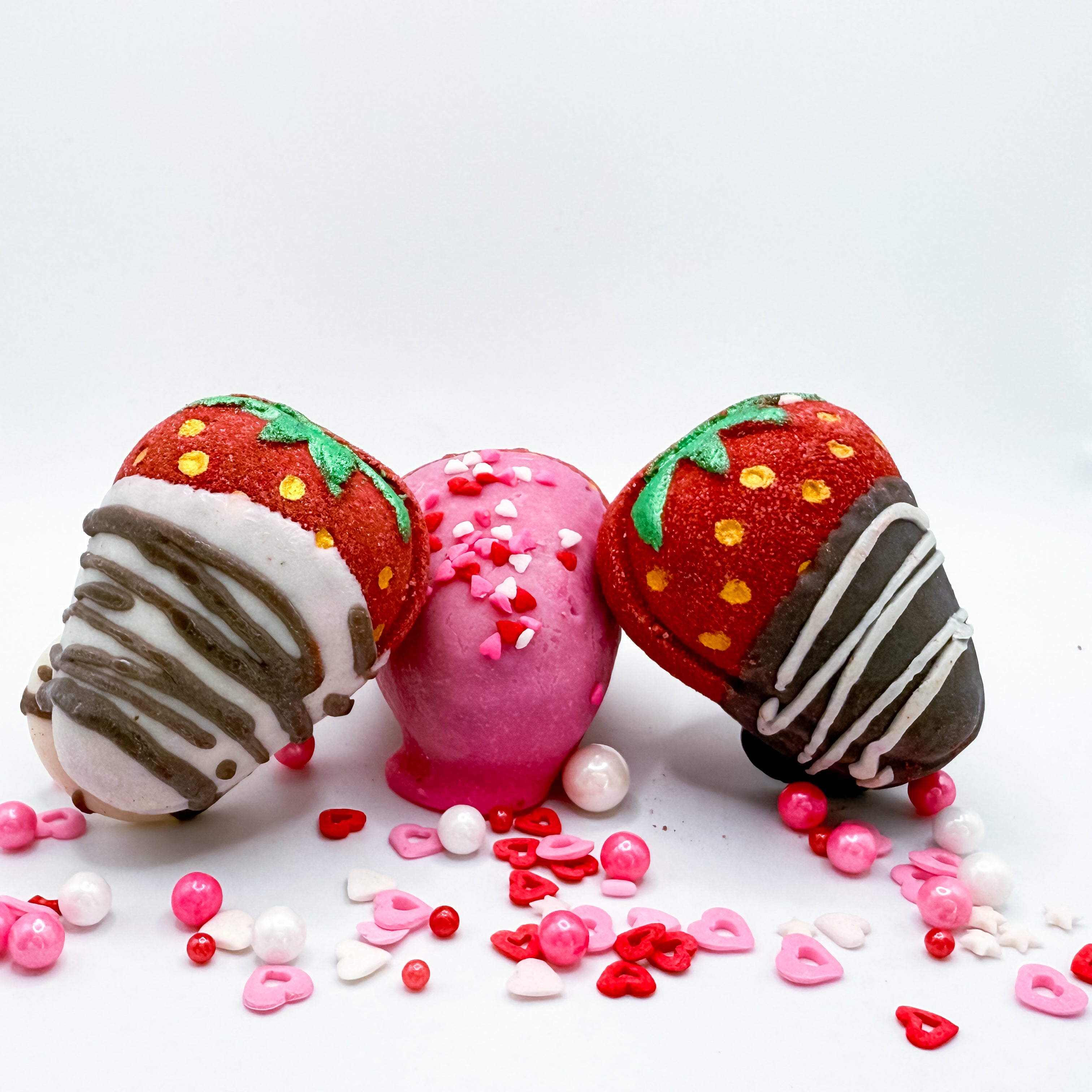 Three chocolate covered strawberry bath bombs made by Rusted Acre Soap Company.