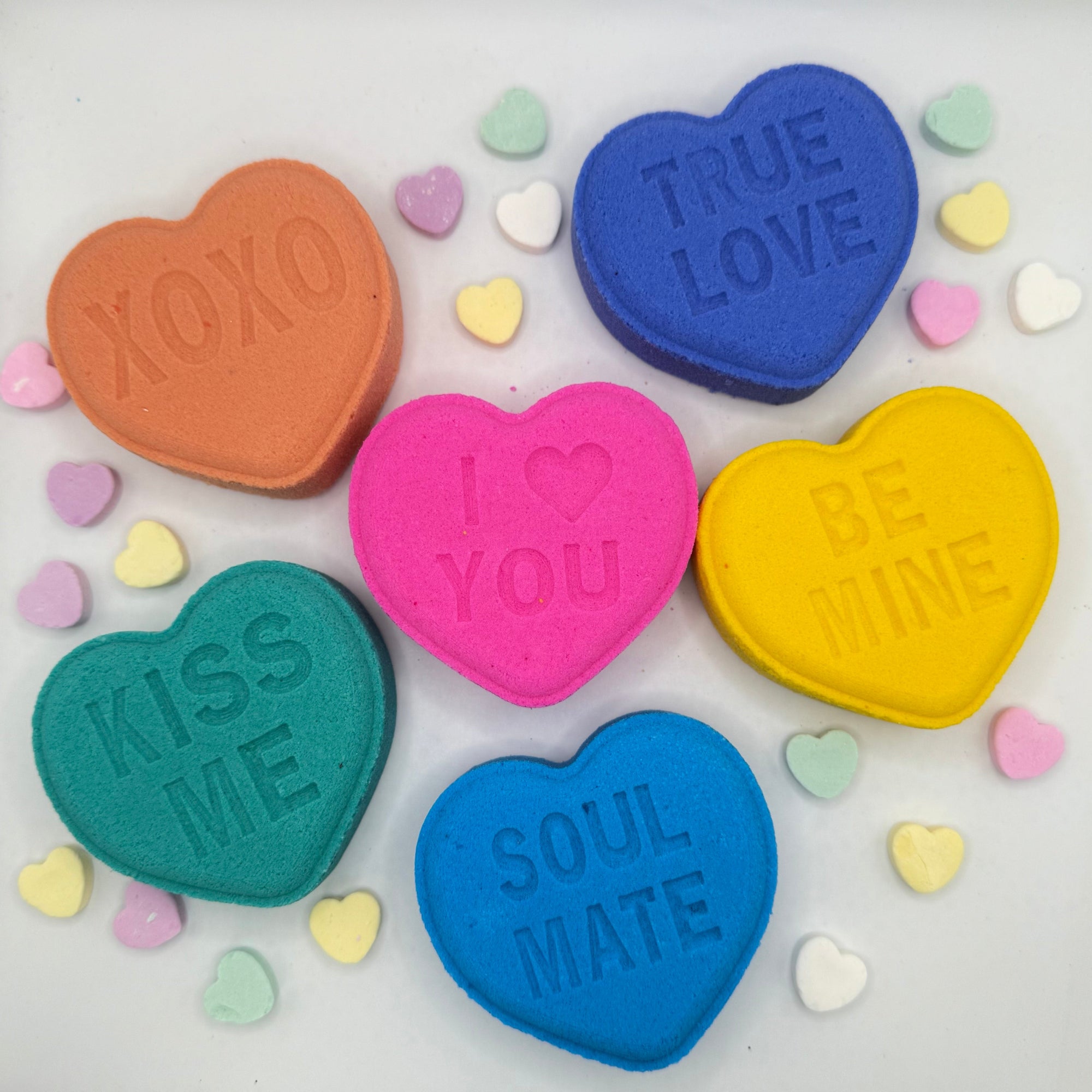 Six conversation heart shaped bath bombs. Colors are the following pastels blue, purple, yellow, green, pink, peach