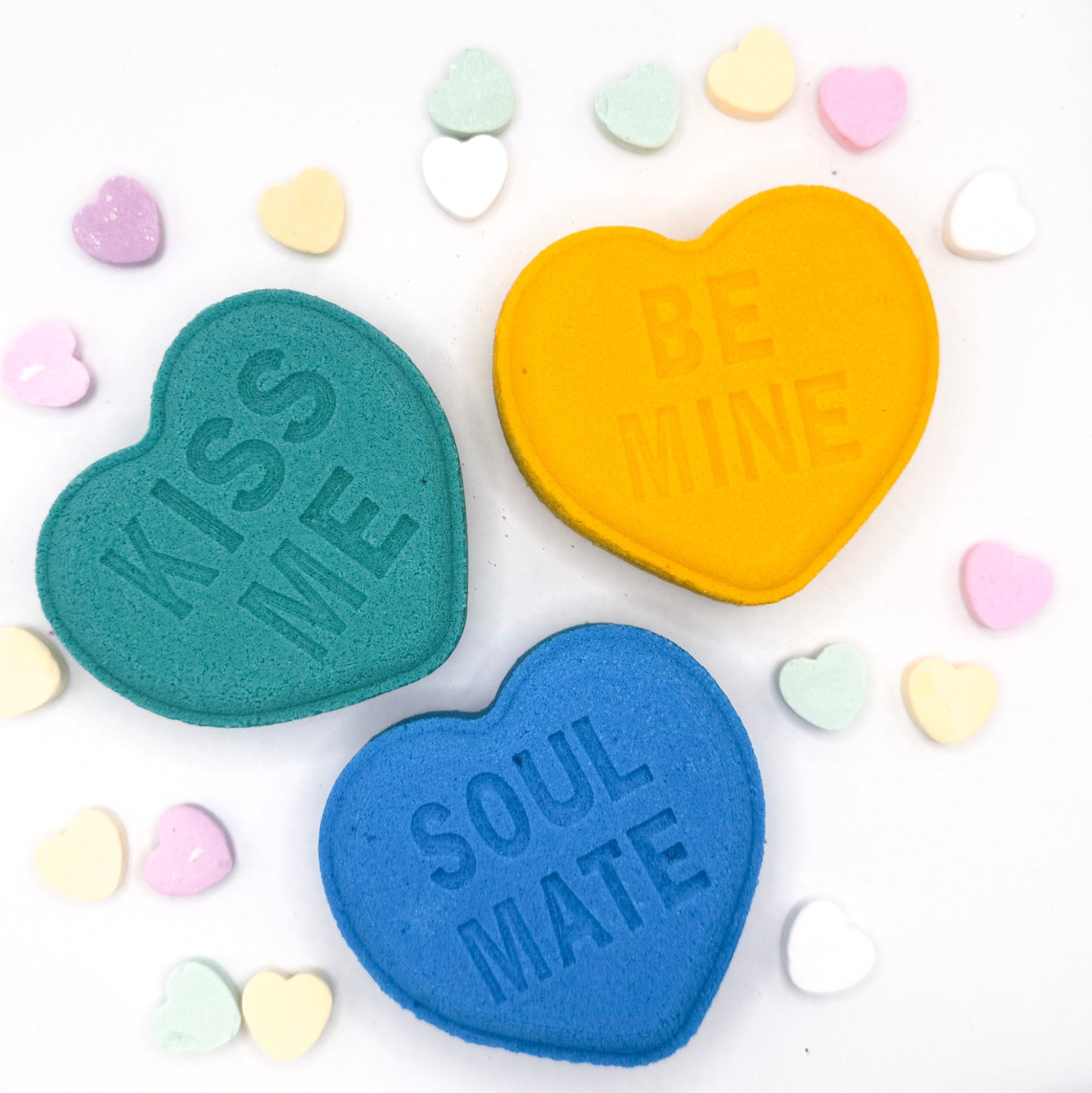 Heart bath bombs with messages from Rusted Acre Soap Company. Three hearts in green, blue and yellow.