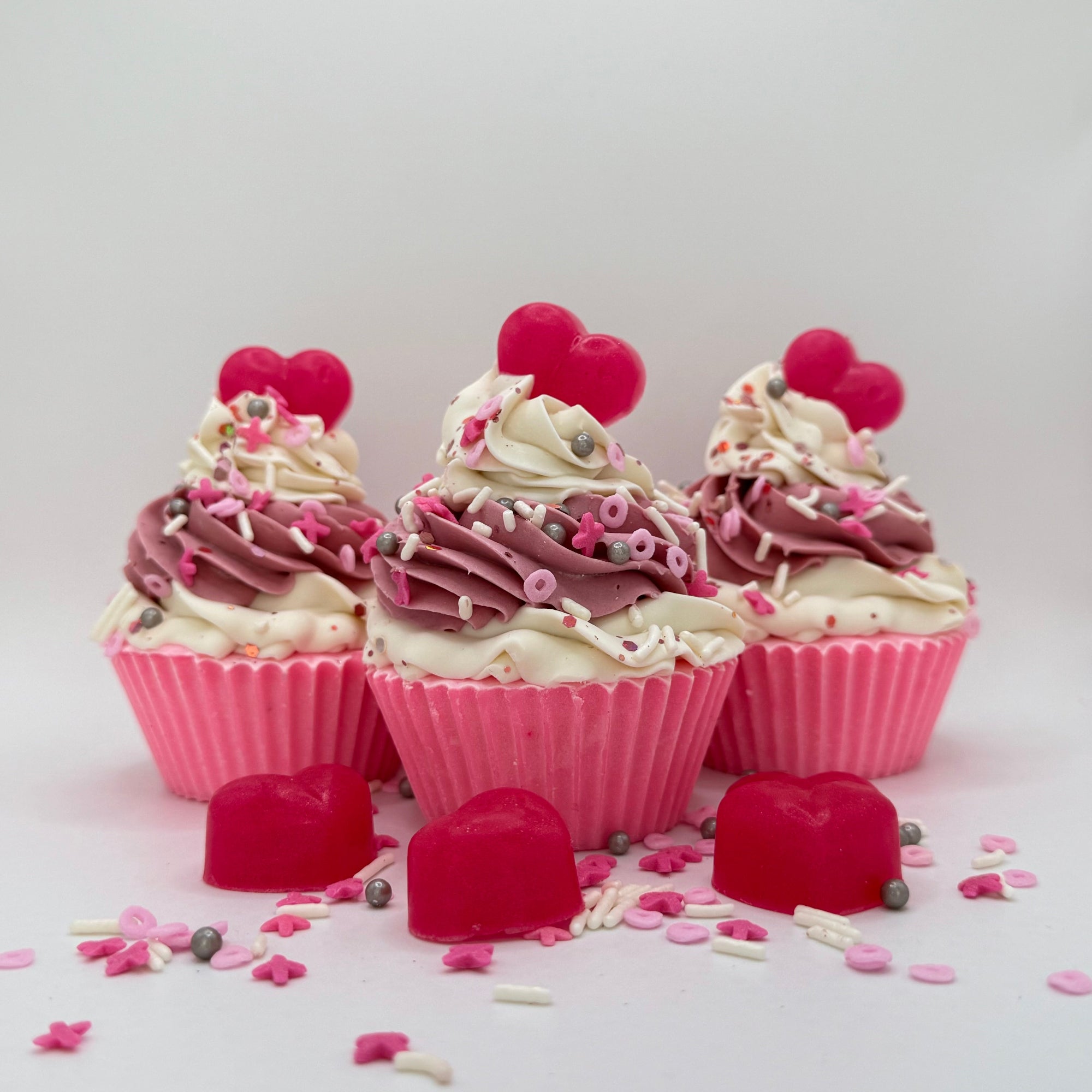 Three heart cupcake soaps from Rusted Acre Soap Co. Pink cake topped with pink and white frosting and pink heart soap embeds.