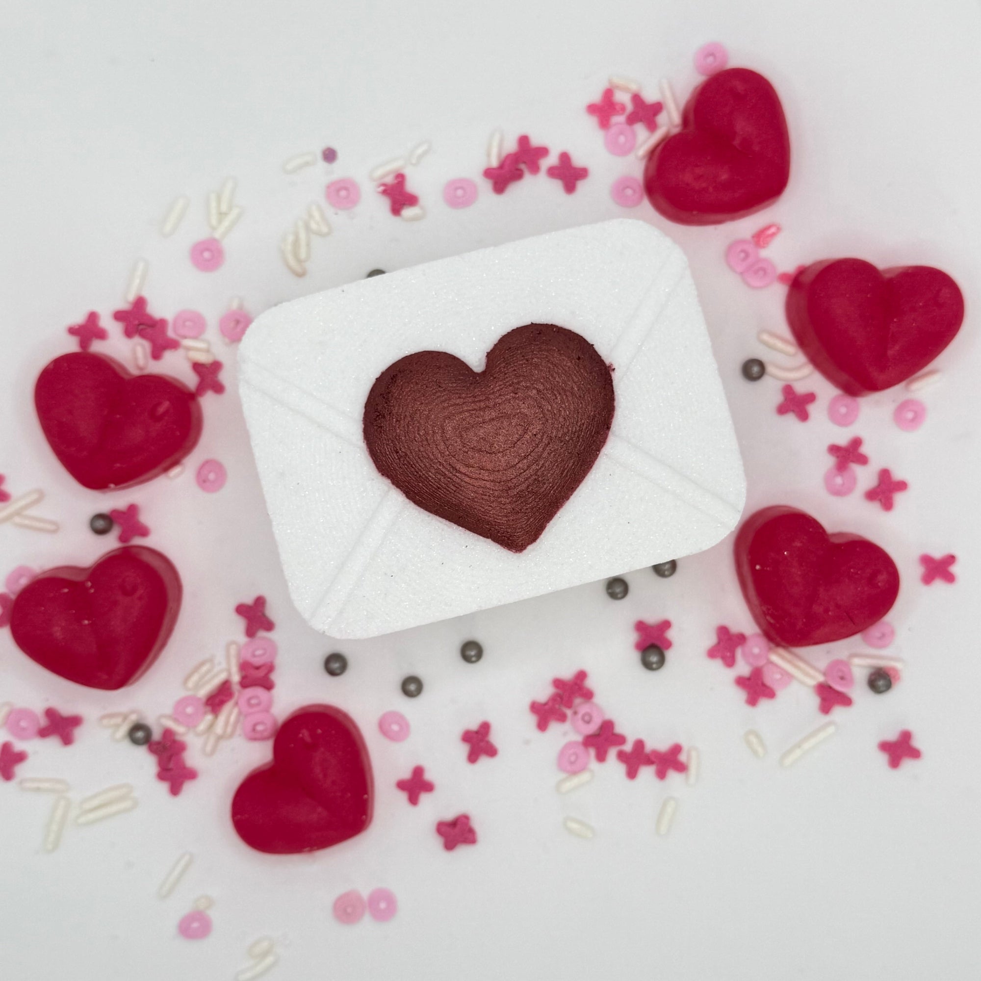 Pink love letter bath bomb with hand-painted raised red heart on the front. 