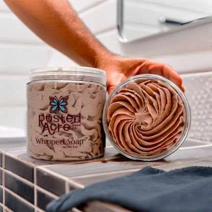 Two jars of Rusted Acre Soap Company's mahogany whipped soap in a lifestyle image.