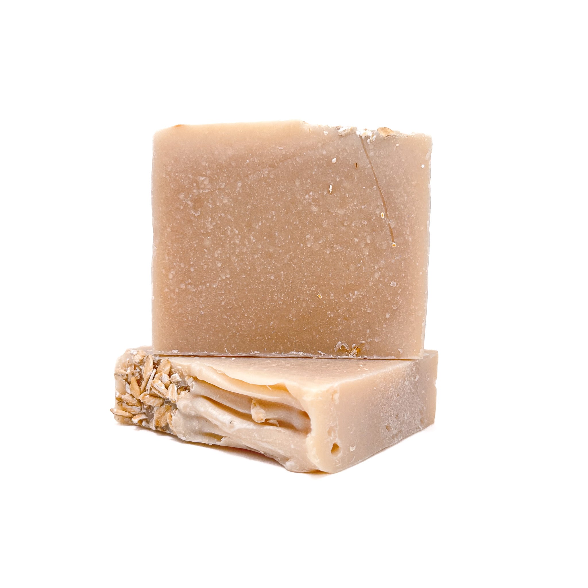 Two bars of natural colored handmade soap. One upright and one lying flat to show texture. 