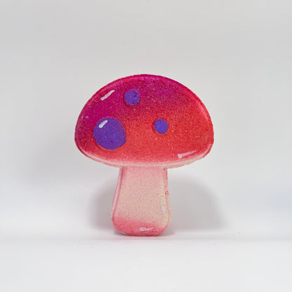 A mushroom shaped bath bomb, airbrushed shimmery pink. Hand-painted purple dots by Rusted Acre Soap Co.