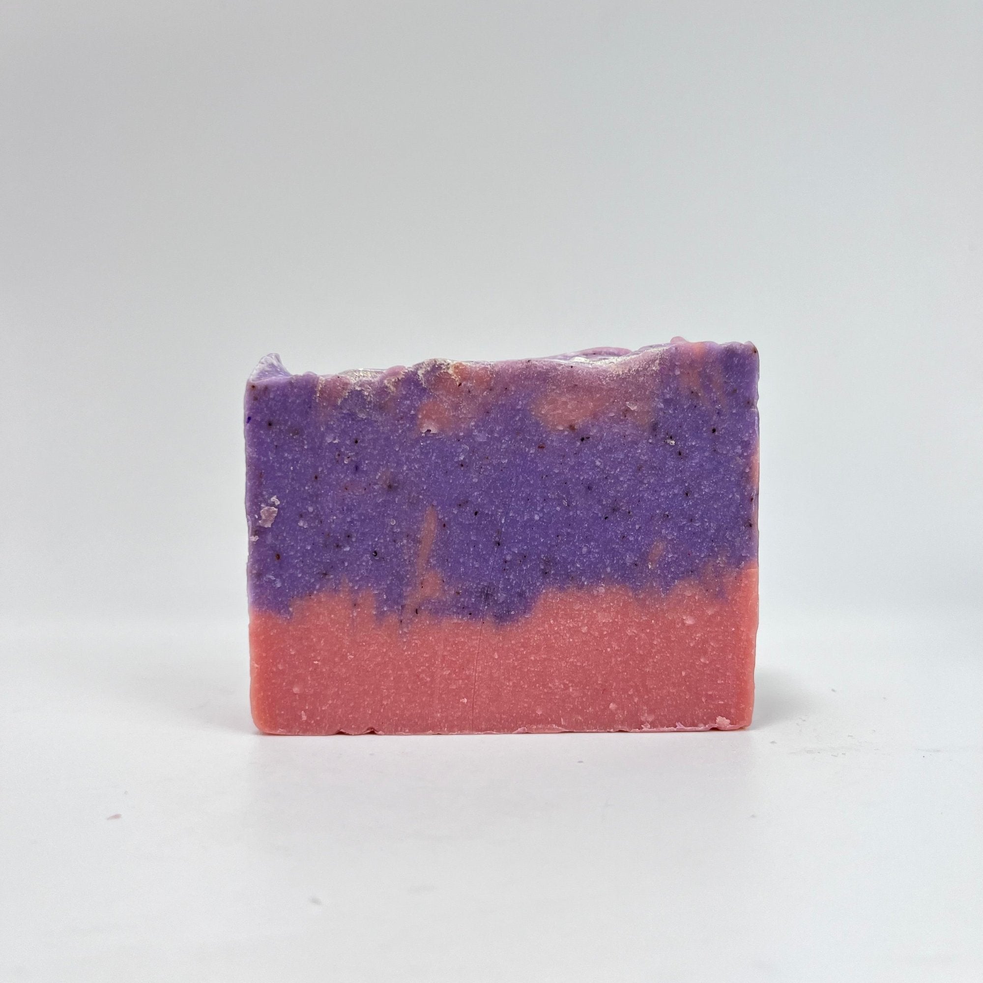 A bar of raspberry vanilla handmade soap. Color is pink bottom, purple and pink swirled upper. Topped with shimmer.