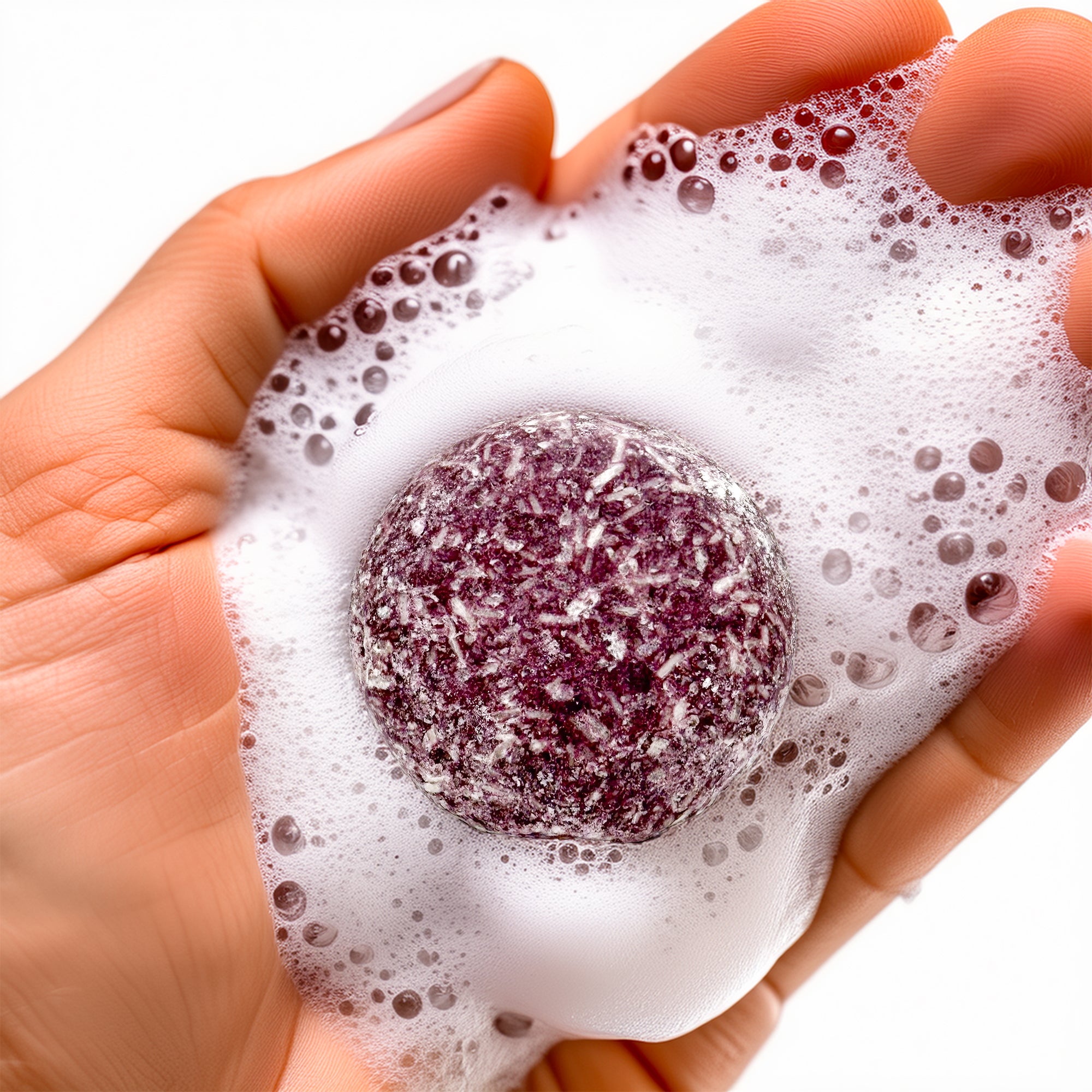 Shampoo bar from Rusted Acre Soap Company in hand with suds around it.