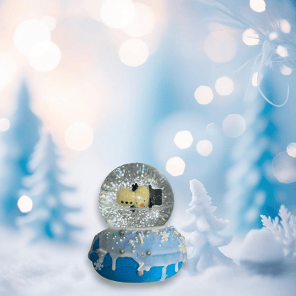 A blue snow globe bath bomb form Rusted Acre Soap Company, topped ith a snowman bouncy ball.