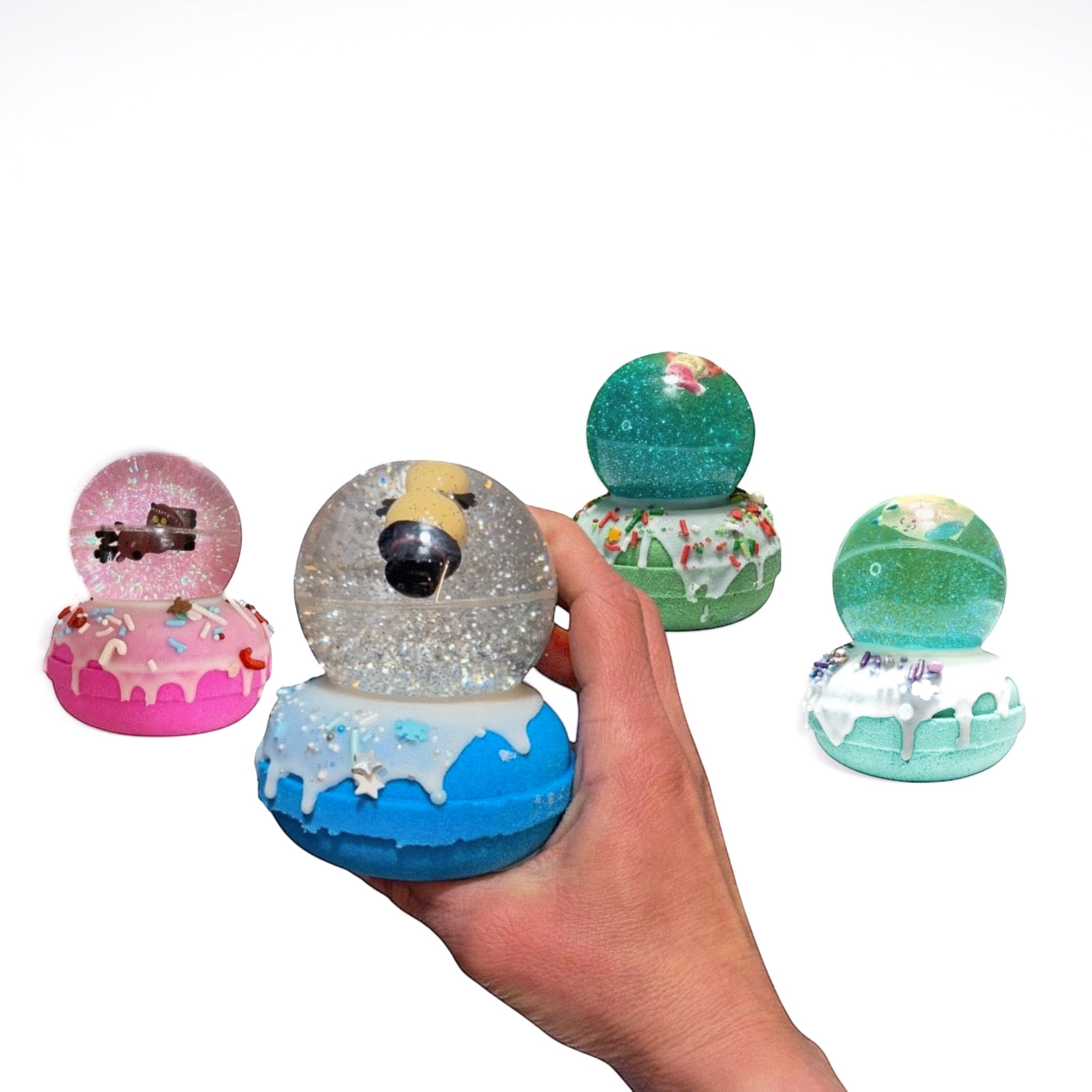 Four Snow Globe bath bombs from Rusted Acre Soap Co.. One in a hand.