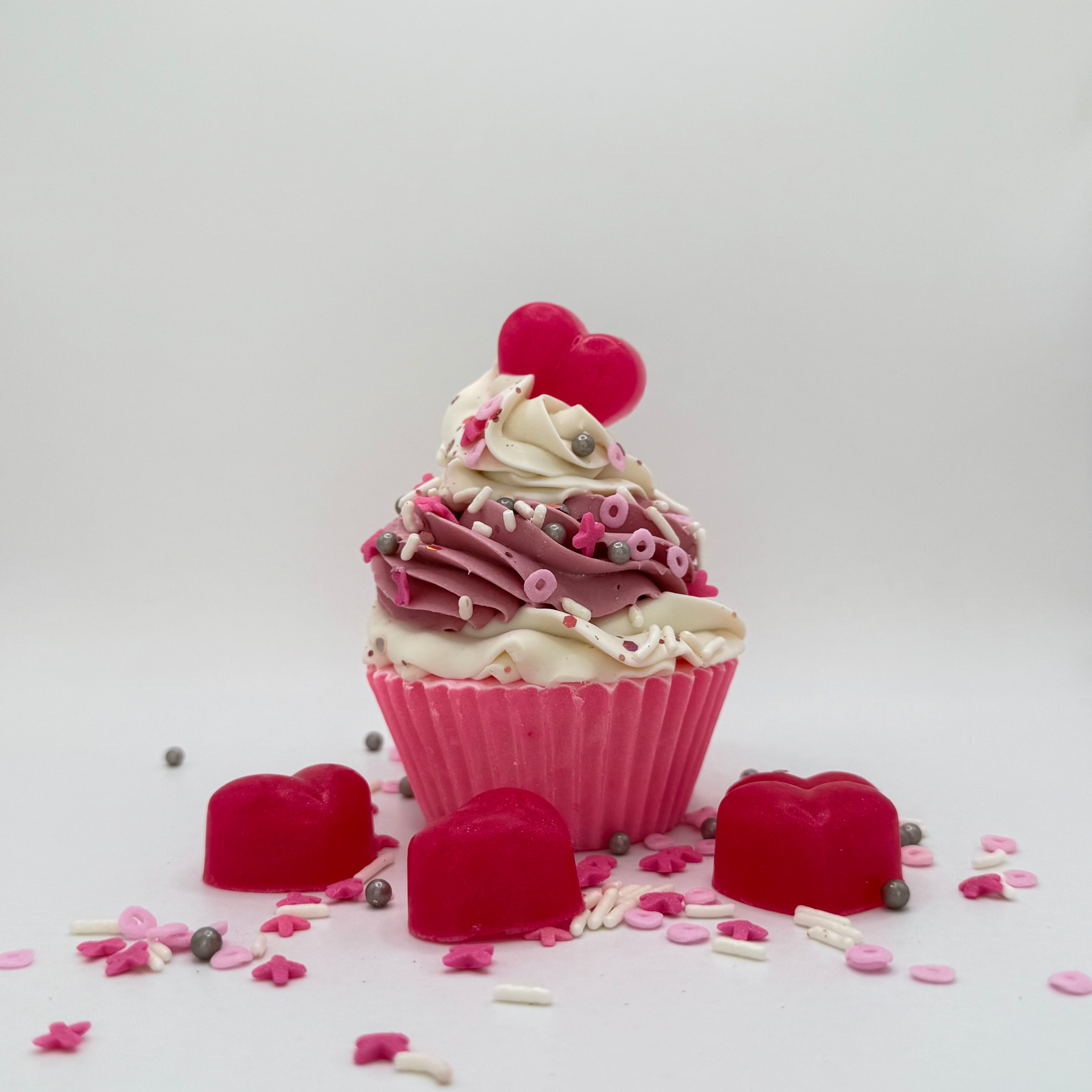 One cupcake shaped soap with pink cake and white pink swirled frosting. Topped with a soap heart and Valentines Da themed sprnkles.